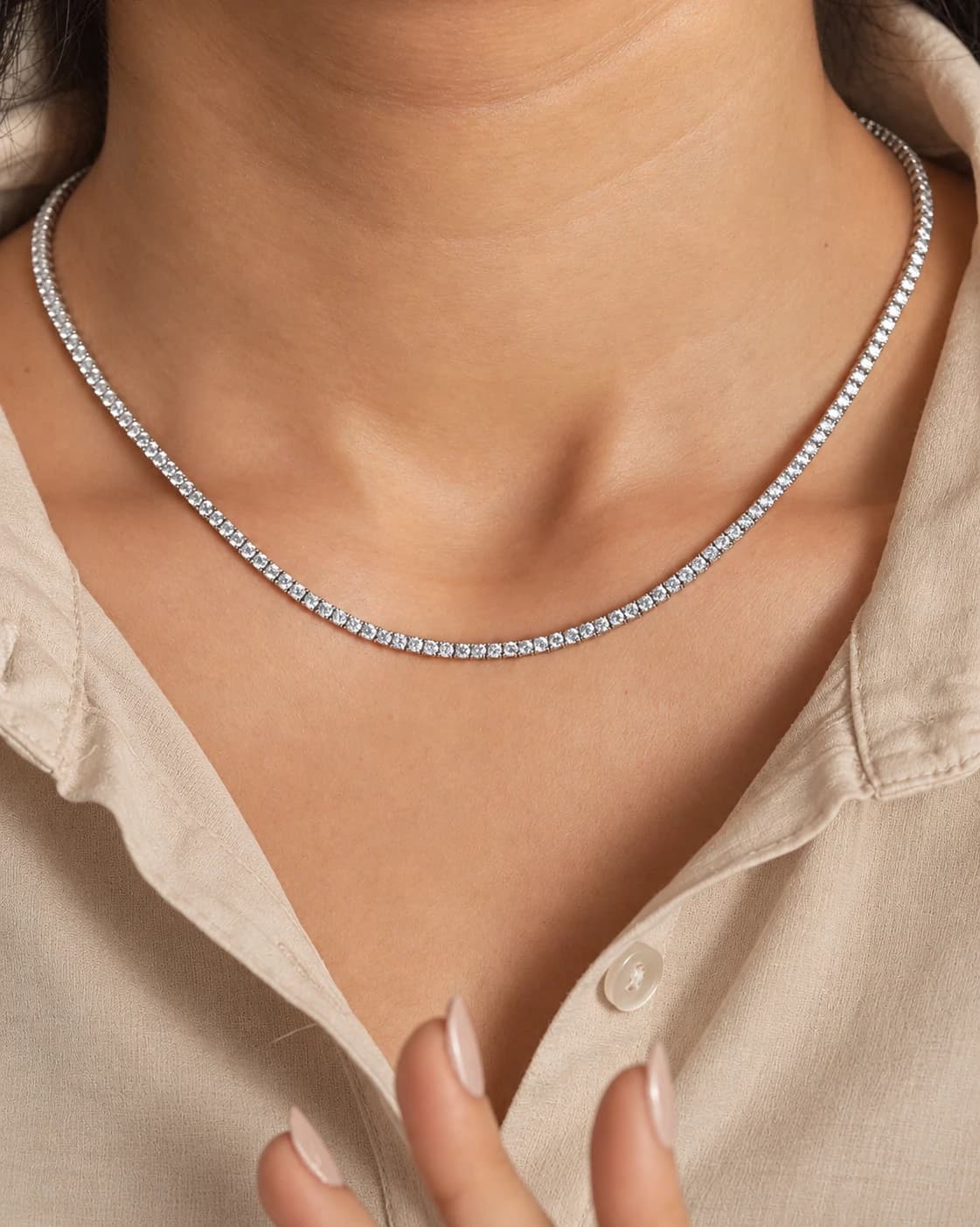 White gold diamond tennis necklace worn with an open-collared linen shirt
